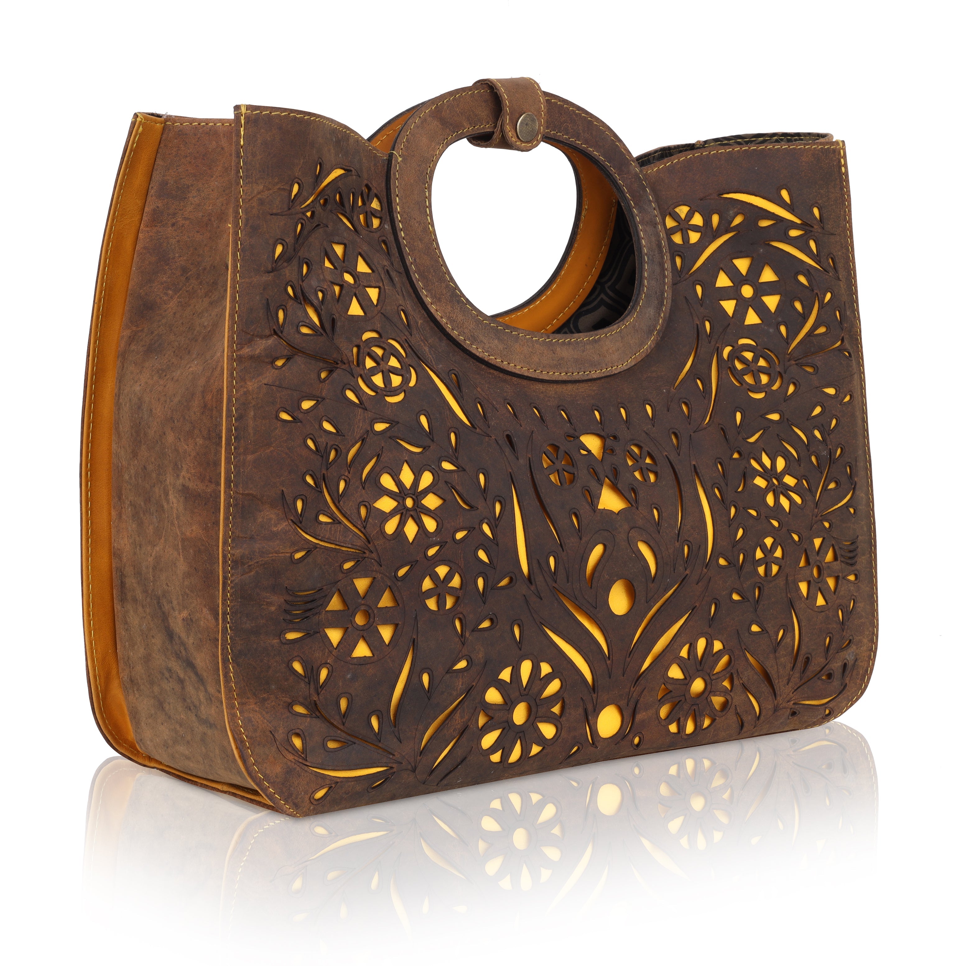 This unique tote bag features an intricate laser-cut floral pattern on rich brown leather, with a golden inner lining that shines through the cutwork for a striking effect