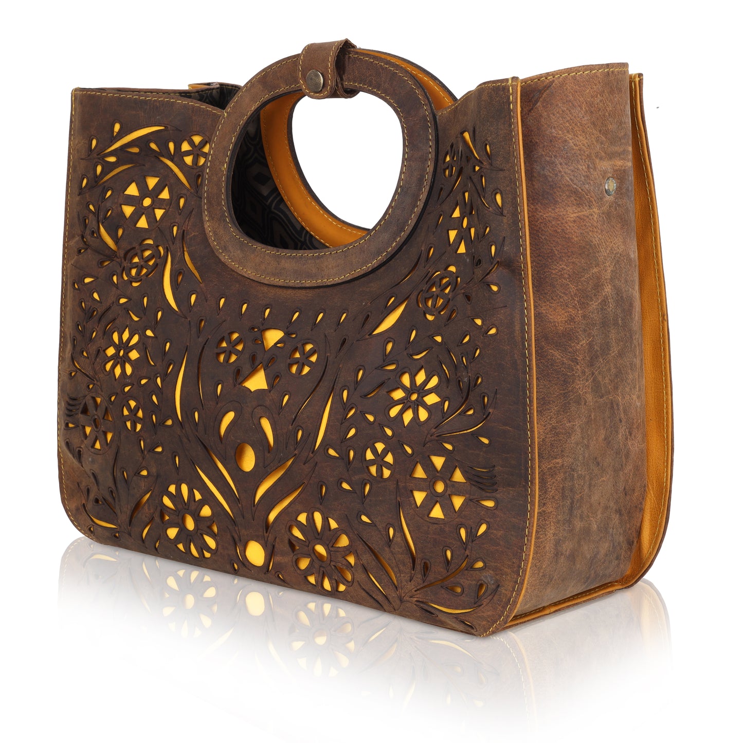 This unique tote bag features an intricate laser-cut floral pattern on rich brown leather, with a golden inner lining that shines through the cutwork for a striking effect