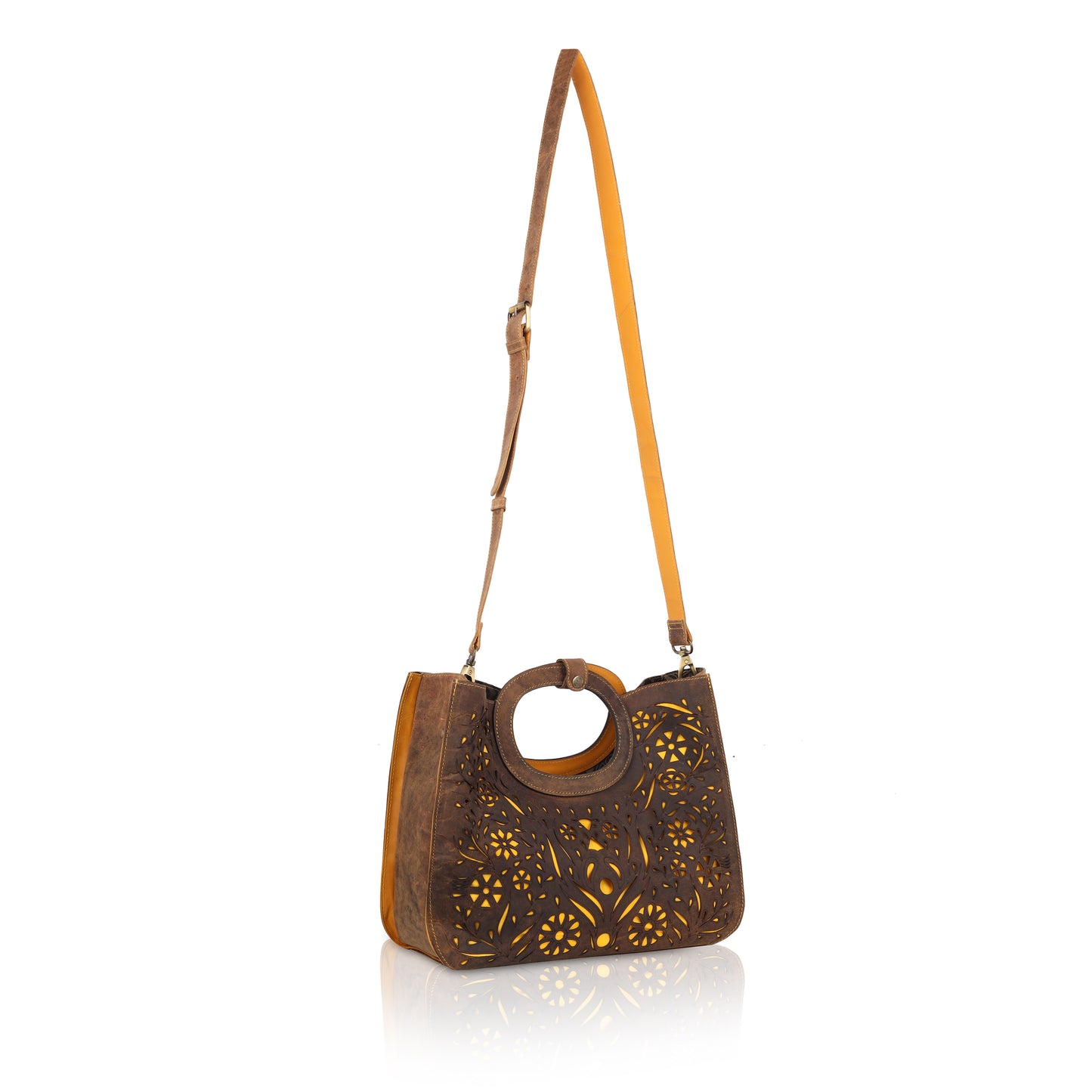This unique tote bag features an intricate laser-cut floral pattern on rich brown leather, with a golden inner lining that shines through the cutwork for a striking effect